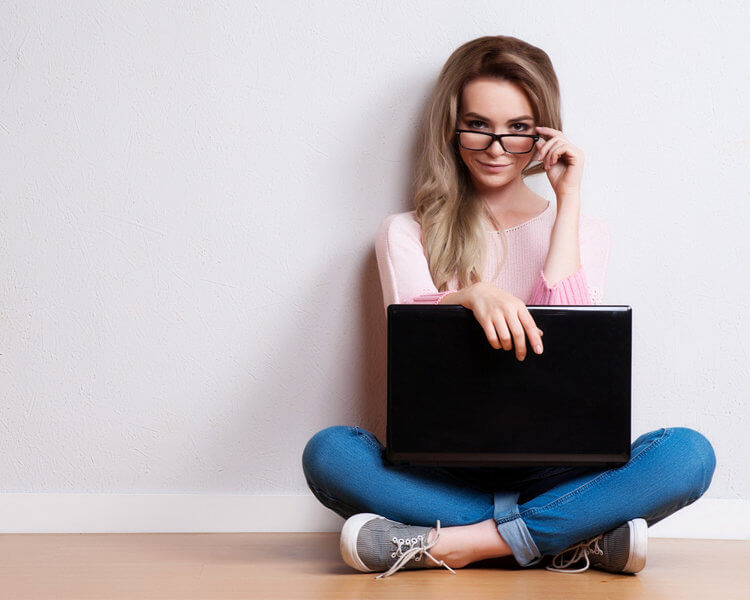 Young creative woman sitting in the floor with laptop