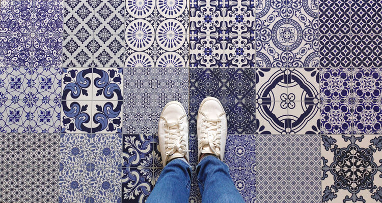 Selfie of feet with sneaker shoes on art pattern tiles floor bac