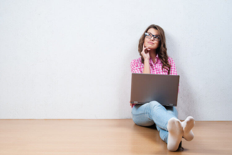 girl sitting floor wall laptop