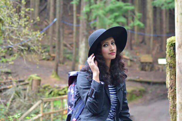 natasha kundi sitting blue jacket hat