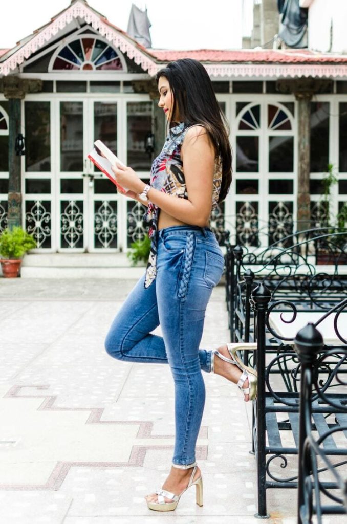 Stylish woman in high heeled shoes reading book