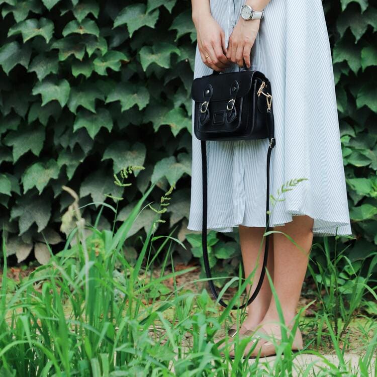 Woman Holding Black Leather Bag Beside Bush