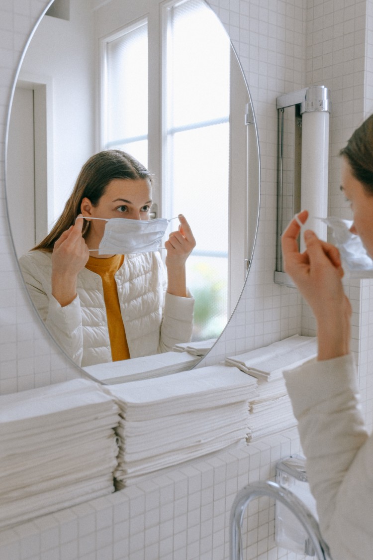 Best Face Masks - Woman putting a face mask in front of the mirror