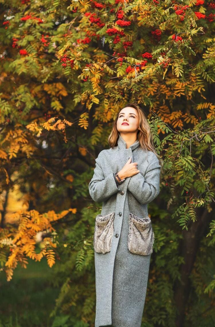 Woman Standing in Nature Wearing an Oversized Jacket