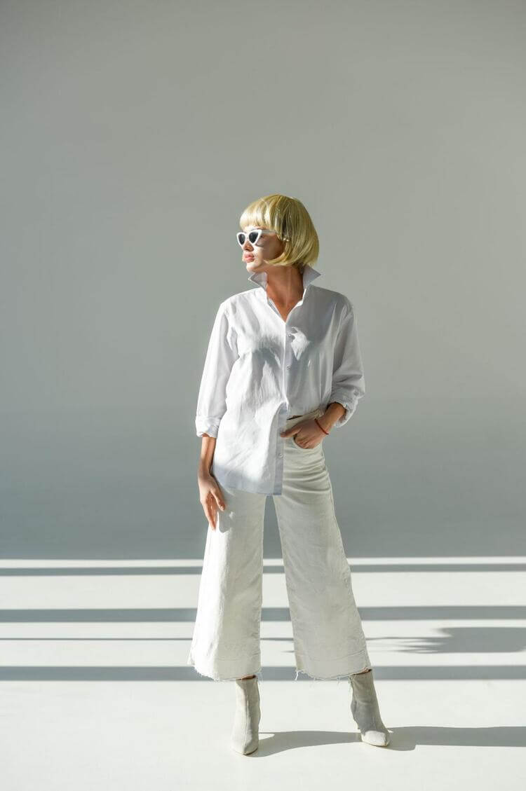 Woman Standing Looking to the Side Wearing All White Clothing